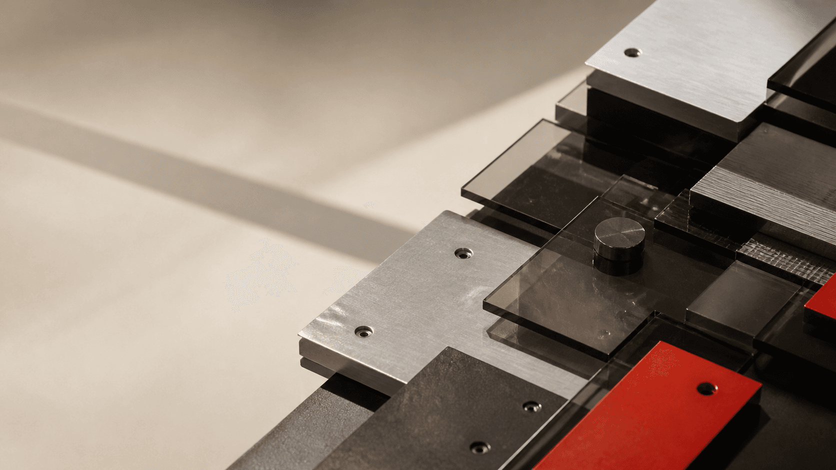 Composición de piezas metálicas y acrílicas que representa un sistema digital modular